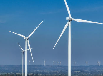 Low angle view of windmill against blue sky