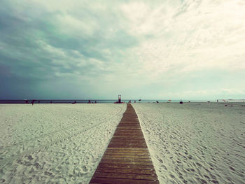 Surface level of footpath by sea against sky