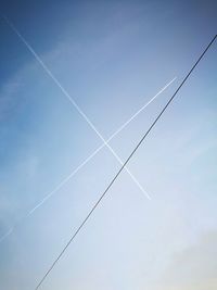 Low angle view of vapor trail against blue sky