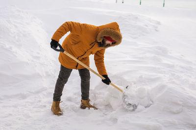 Low section of man skiing on snow covered field