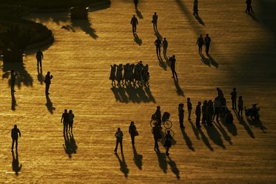 High angle view of people walking on footpath during sunset