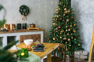 Home new year's interior. christmas tree with gifts, decorated with garlands in the kitchen. 