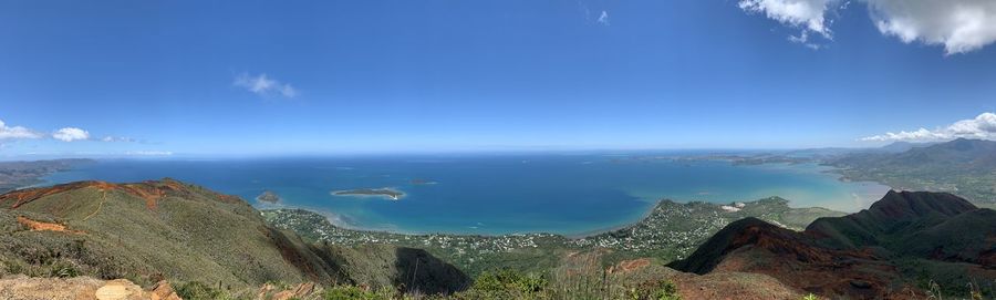 Panoramic view of sea and mountains against blue sky