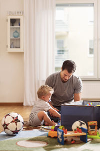 Father and son playing with toys at home