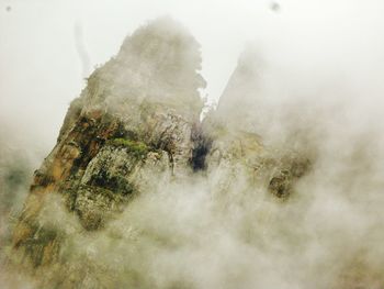 Scenic view of mountains against sky during foggy weather