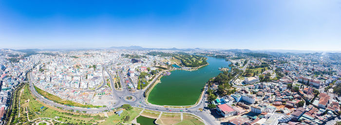 High angle view of city buildings against blue sky