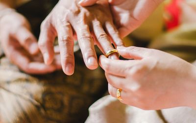 Cropped image of woman putting ring in finger of mother