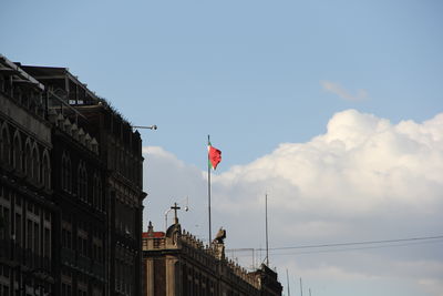 Low angle view of flag on building against sky