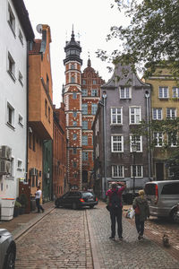 People walking on street amidst buildings in city