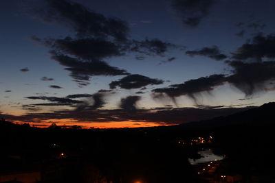 Silhouette of mountain against cloudy sky at sunset