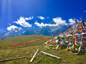 Colorful flags on mountain against blue sky during sunny day