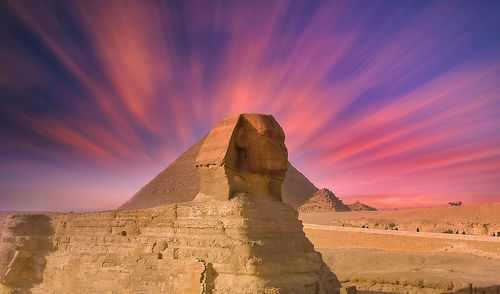 Rock formations in desert against sky during sunset