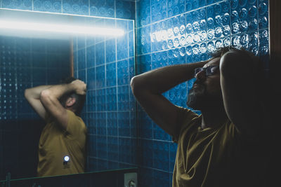 Side view of depressed man standing in bathroom