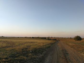 Empty road on field against sky