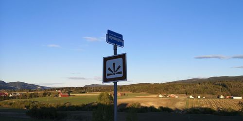 Road sign against blue sky