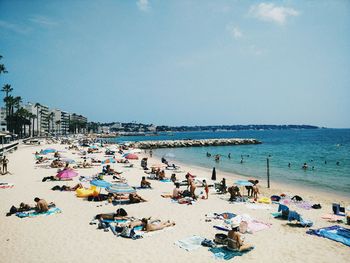 People at beach against clear sky