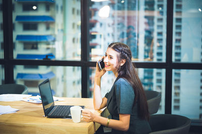 Woman using mobile phone in office