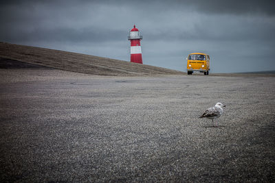 View of lighthouse by sea against sky