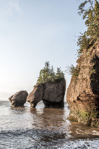 Rocks in sea against sky