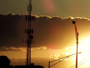 Low angle view of silhouette electricity pylon against sky during sunset