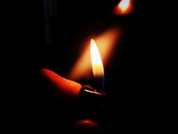 Close-up of lit candle in dark room