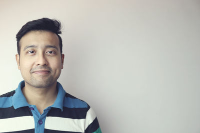 Portrait of young man standing against wall