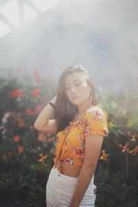 Beautiful woman standing by railing in park