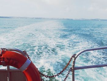 Close-up of boat sailing in sea against sky