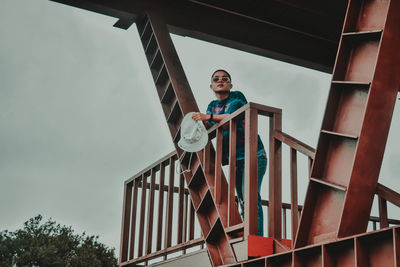 Low angle view of young man against sky