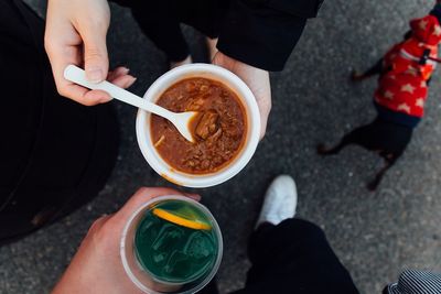 Cropped image of people with food and drink on street