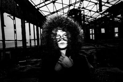 Portrait of young woman wearing mask in abandoned house