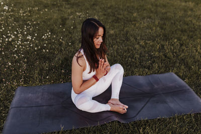 Full length of woman sitting on field