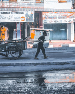 Side view of man standing on street in city