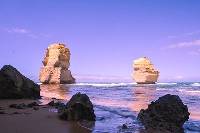 Rock formation on beach against sky