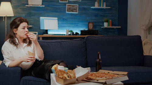 Woman sitting on sofa at home