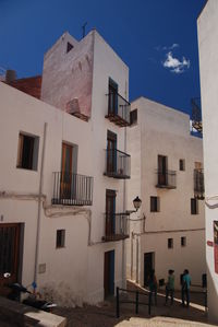 Low angle view of buildings in spanish city against sky