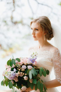 Close-up of woman with pink flowers against blurred background