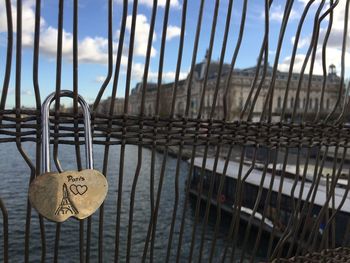 Close-up of padlocks on railing against sea