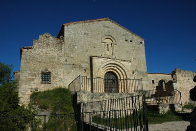 Low angle view of old building against clear blue sky