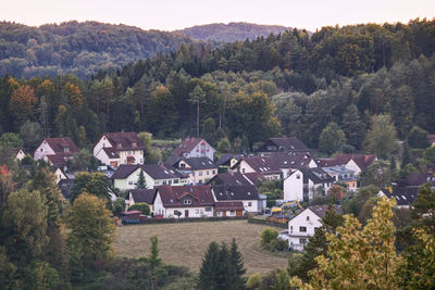 High angle view of houses amidst trees and buildings