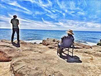 Rear view of man looking at sea against sky