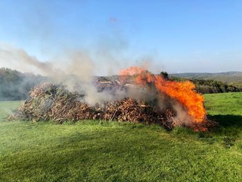 Panoramic view of bonfire on field against sky