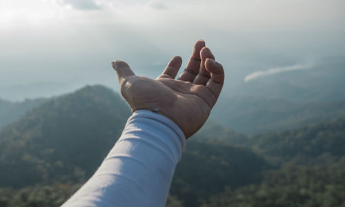 Hands outstretched to receive natural light and mountain views