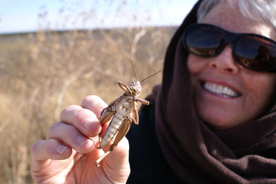 Close-up of woman holding insect