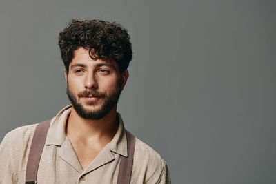 Portrait of young man against gray background