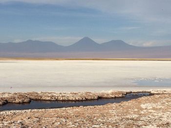 Scenic view of lake by mountains against sky