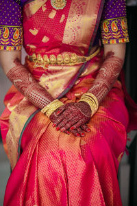 Midsection of bride wearing sari and jewelry