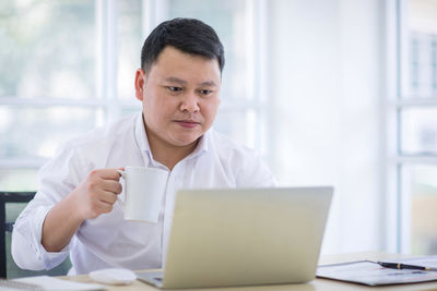 Mid adult man using laptop on table