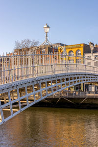 Bridge over river in city against clear sky