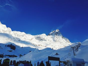 Scenic view of snowcapped mountains against blue sky